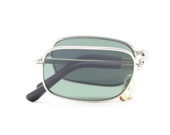 Occhiali da sole pieghevoli vintage anni '90. Montatura rettangolare minimalista in argento satinato con lenti verdi. Nuovi di zecca. Pieghevoli. Anni 2000. Anno 2000. NOS.