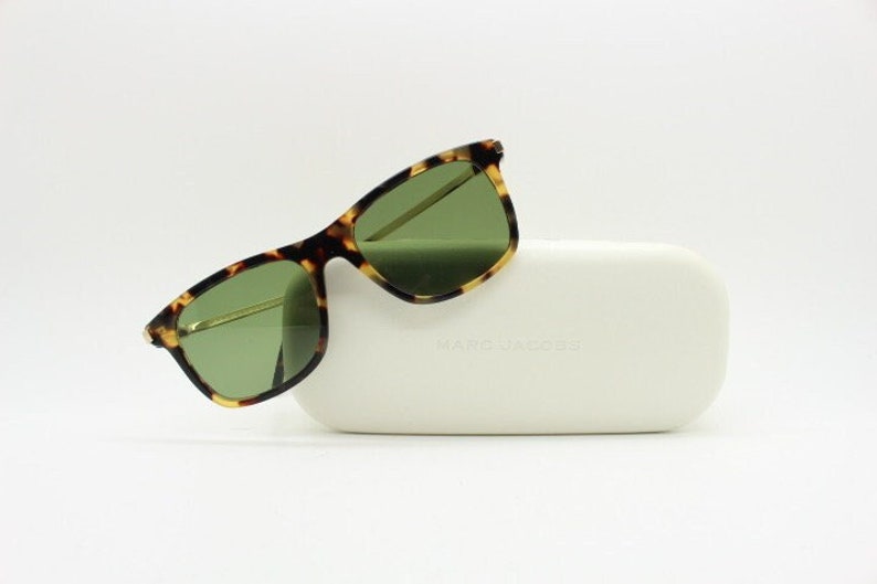 May include: Tortoiseshell sunglasses with green lenses and a white case that says "MARC JACOBS".