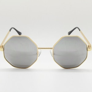 May include: Gold-framed sunglasses with octagonal lenses and a mirrored finish.