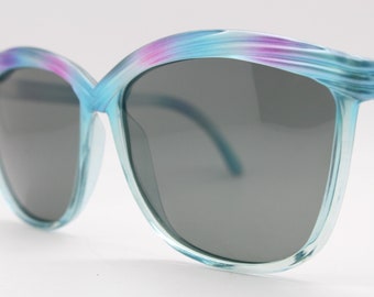 80er Jahre Vintage große Cateye Sonnenbrille. Klarer himmelblauer und pinker Katzenaugenrahmen mit schwarzen Gläsern. nr. 70er Jahre