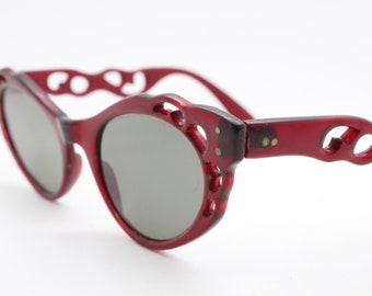 50s vintage womens pointed cat eye sunglasses. Ornately carved cut out oxblood cateye frame with luxury real mineral glass lenses