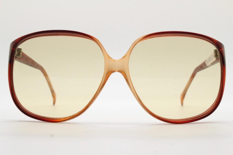 Op de afbeelding: Oversized vintage zonnebril met een bruin schildpadmontuur en lichtgele glazen. De bril heeft een kenmerkende vlindervorm, met een brug en pootjes in een lichtere bruintint. Een klassiek retro-accessoire.