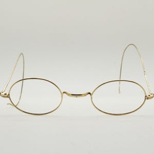 Victorian vintage metal oval eye glasses. Gold wire optical frame with coiled arms. Prescription Civil War 1800s spectacles. Good condition