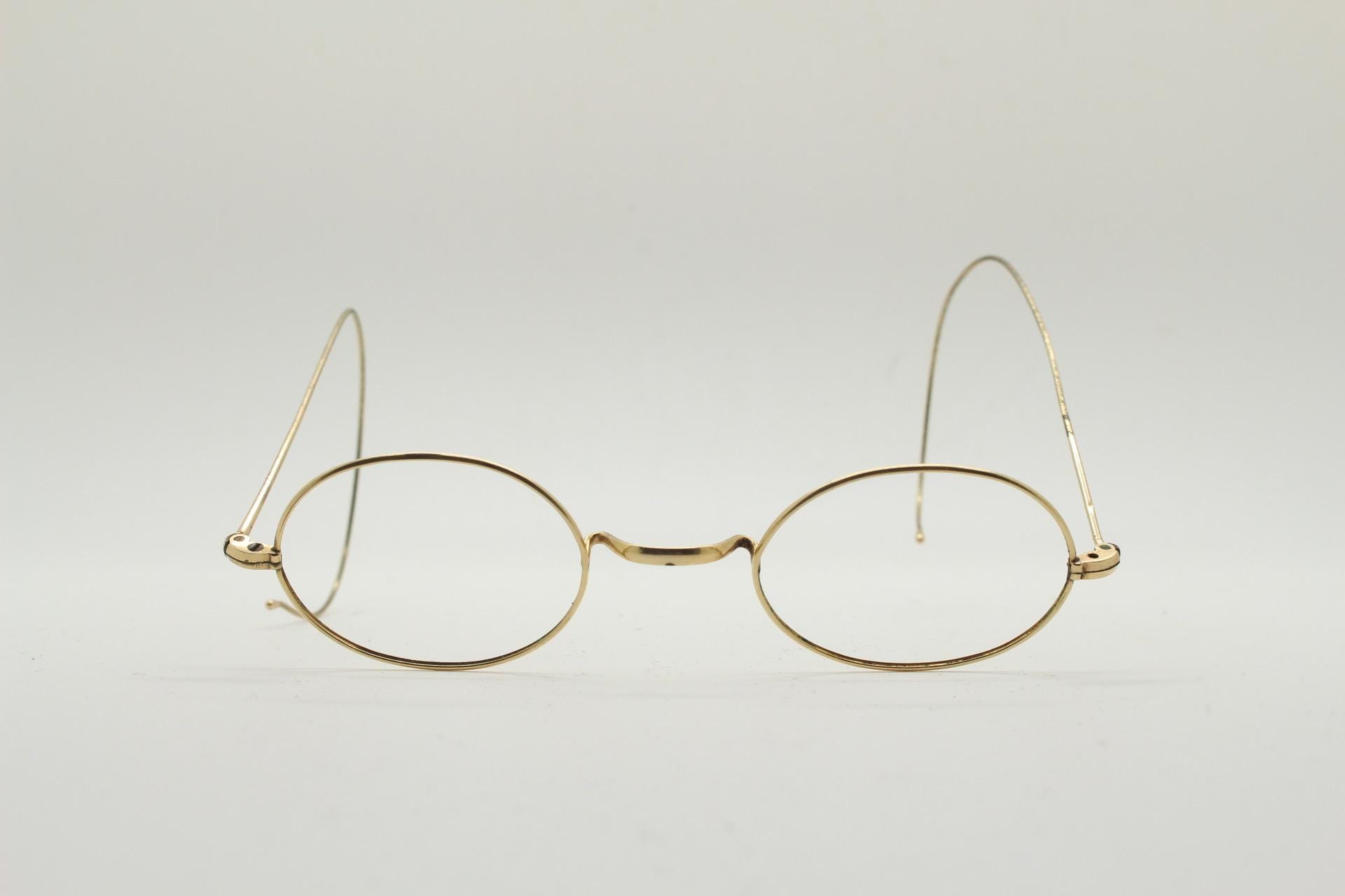 Victorian vintage metal oval eye glasses. Gold wire optical frame with coiled arms. Prescription Civil War 1800s spectacles. Good condition