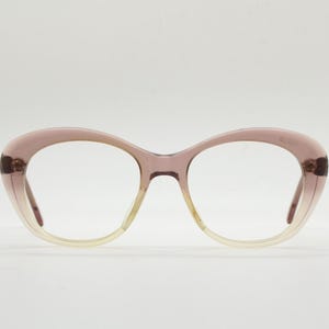 May include: A pair of pink cat-eye glasses with clear lenses.