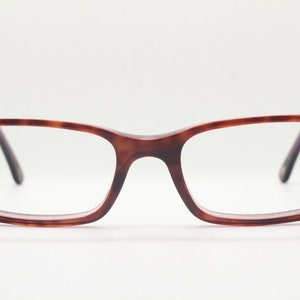 May include: A pair of tortoiseshell spectacles with a rectangular frame.