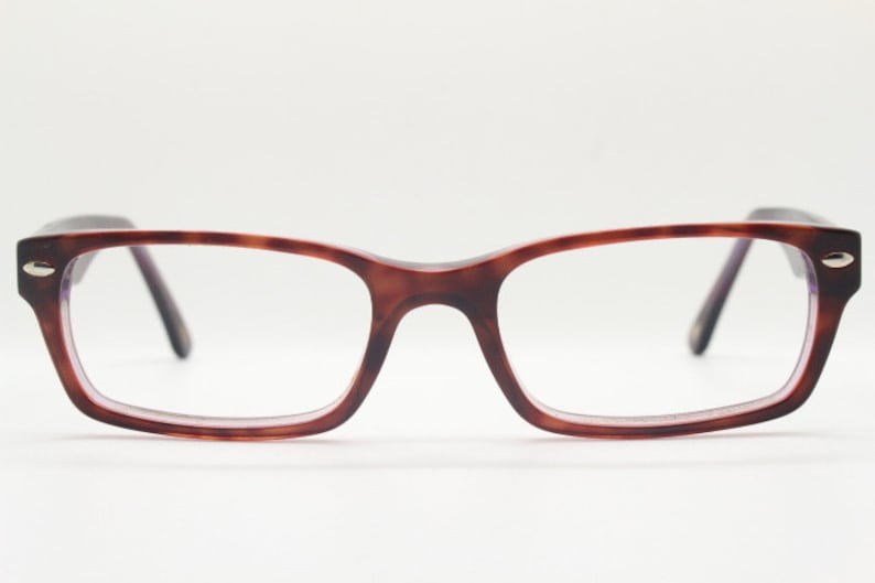 May include: A pair of tortoiseshell spectacles with a rectangular frame.
