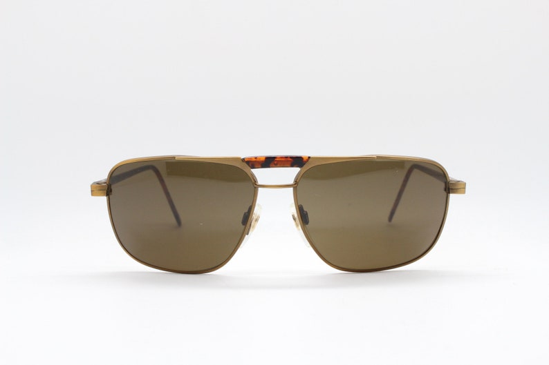 May include: Gold-tone aviator sunglasses with brown lenses and a tortoise shell bridge.