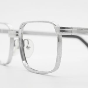 May include: Silver-toned metal eyeglasses with a rectangular frame and thin arms.