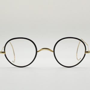 20s vintage antique round glasses. Black gloss surrounds on a gold optical frame with coiled arms. Prescription eyeglasses. 30s spectacles