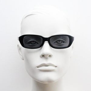 60s Vintage rechteckige Sonnenbrille mit tiefem Profil. Minimalistischer schlichter schwarzer Glanzrahmen. Ausgezeichneter NOS-Zustand. Herrenschlaghose