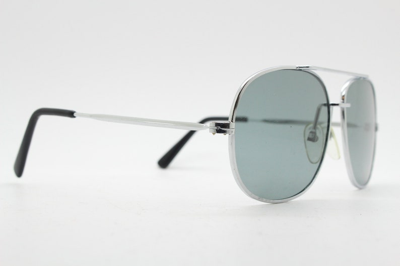 May include: Silver aviator sunglasses with gray lenses and black temple tips.