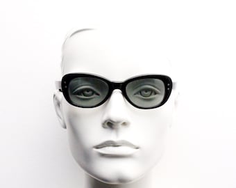 60s vintage cat eye sunglasses by Polaroid. Sophisticated womens black rounded cateye frame with convex lenses. 50s rockabilly pin up