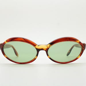 60s stylised oval vintage sunglasses. Mottled honey brown acetate frame with luxury green glass lenses and thickened brows. Mod. Unworn NOS
