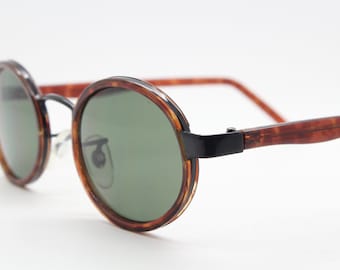 90s vintage oval sunglasses. NOS black metal frame encasing tortoise insert with green lenses. BNWT