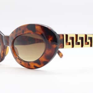 90s vintage oval cat eye sunglasses. Chunky womens cateye with vibrant tortoise face and awesome gold arm pattern. Unused NOS