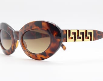 90s vintage oval cat eye sunglasses. Chunky womens cateye with vibrant tortoise face and awesome gold arm pattern. Unused NOS