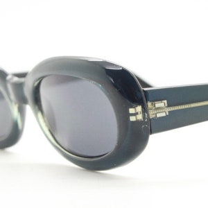 90s vintage oval sunglasses. Curved low profile pearlised chunky blue grey frame with black lenses. Unused NOS. Y2K, 2000s