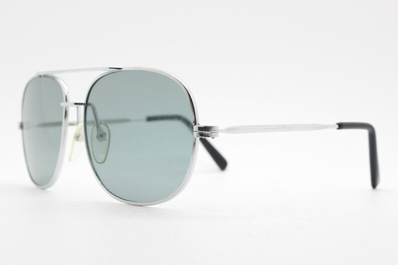 May include: Silver aviator sunglasses with gray lenses and black arms.