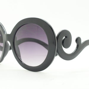 Y2K vintage oversized round sunglasses. Women's black gloss frame with smoky gradient lenses and swirling arms. Unused NOS. 2000s