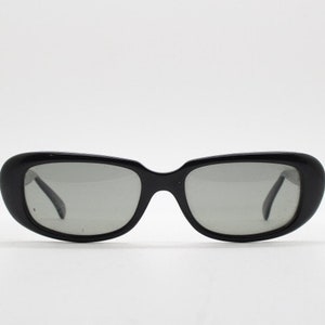 60s vintage oval cat eye sunglasses by Polaroid. Sophisticated womens black rounded cateye frame with convex lenses. 50s rockabilly pin up