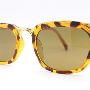 May include: Tortoise shell sunglasses with gold metal accents and brown lenses.