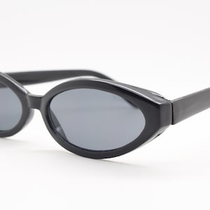 90s vintage cateye sunglasses. Sharp angled black oval cat eye with slender frame. BNWT. Rockabilly. Unused NOS