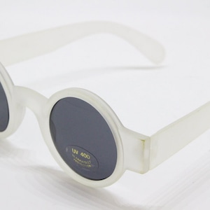 May include: White plastic round sunglasses with dark lenses. The sunglasses have a UV 400 label on the right lens.