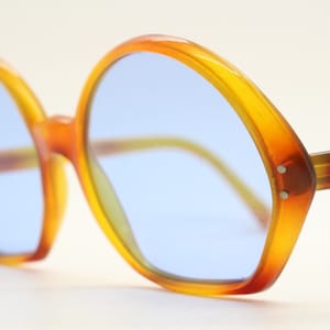 Occhiali da sole rotondi oversize anni &#39;60, realizzati in Francia. Splendida montatura da donna color ambra con lenti in vero vetro azzurro cielo. Anni &#39;70