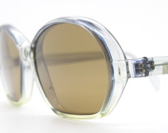 Primetta 60s Vintage Sonnenbrille mit flachem Boden aus Acetat in Deutschland hergestellt. Transparent grauer Rahmen mit dunkelbraunen Gläsern. Neuer Altbestand
