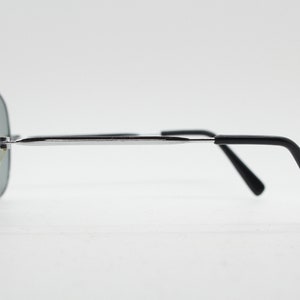 May include: Silver aviator sunglasses with black arms. The sunglasses have a mirrored lens.