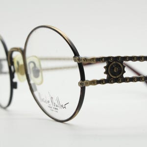 Lunettes de vue rondes vintage des années 90 Nicole Miller. Monture optique en métal d'aspect bronze usé avec des détails de bras extraordinaires. Réception d'ordonnance. BNWT. NSA