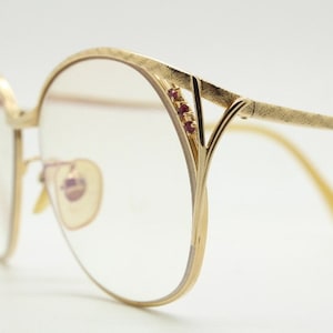 70s vintage 12K gold filled round cat eye glasses. Ornate embossed arms and pink diamante details. Prescription eyeglasses. Optical frames