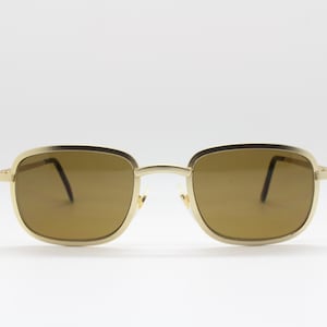 May include: Gold-tone square sunglasses with brown lenses.
