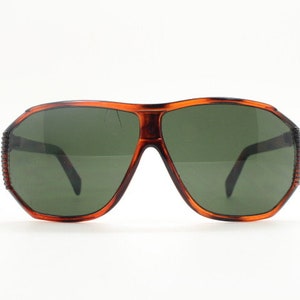 May include: A pair of brown tortoise shell aviator sunglasses with green lenses.