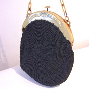 Lovely 1920s black knitted pouch bag on sweetly carved plastic frame
