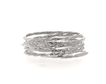 May include: A silver-colored ring composed of multiple twisted bands. The bands have a textured, hammered appearance, creating a unique and eye-catching design. The ring is set against a plain white background.