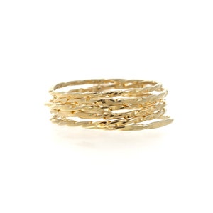 May include: A stack of gold-colored rings with a twisted rope design. The rings are made of a shiny, metallic material and are arranged in a spiral shape. The rings are on a white background.