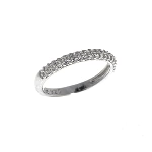 May include: A silver band ring with a row of small clear cubic zirconia stones around the top of the band. The ring is marked with "925" on the inside.