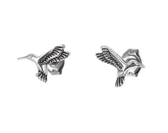 Könnte beinhalten: Ein Paar silberne Kolibri-Ohrringe. Die Kolibris sind im Flug und haben detaillierte Flügel.