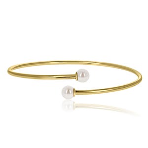 May include: A gold bangle bracelet with two white pearl accents.
