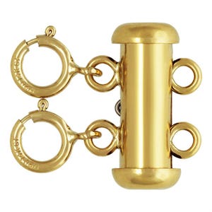 May include: Gold-toned metal connector with two jump rings on each side. The connector has a cylindrical shape with rounded ends. The jump rings are marked with "14K" and "750".
