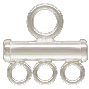 May include: Silver-toned metal jewellery connector with a single loop at the top and three loops at the bottom. The connector is designed to attach multiple strands of beads or charms.