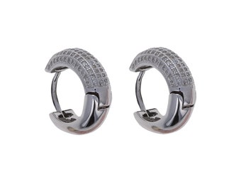 May include: A pair of silver hoop earrings with a row of small clear cubic zirconia stones around the edge.
