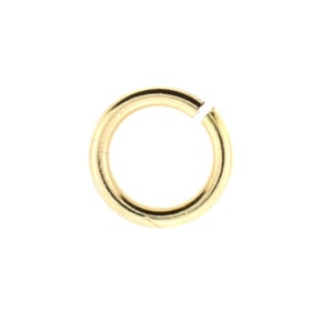 May include: A gold-colored jump ring, a small metal ring used for connecting jewelry pieces.