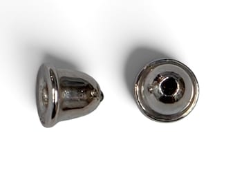 May include: Two silver-toned metal earring backs with a bell-shaped design. One earring back is shown from the side, displaying its curved profile, while the other is shown from the top, revealing the central circular opening for an earring post.