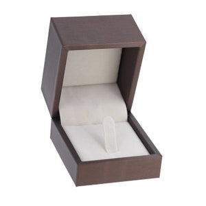 May include: A brown ring box with a white velvet interior and a ring holder.