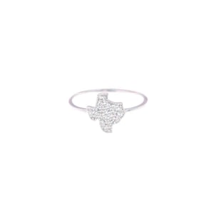 May include: A silver ring with a Texas-shaped design. The Texas outline is filled with small, sparkling stones. The ring has a thin band. The image is set against a white background.
