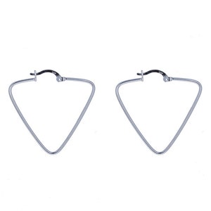 May include: A pair of silver triangle hoop earrings. The earrings are made of a thin metal wire and have a simple, modern design.