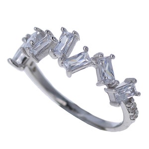 May include: A silver ring with a row of baguette-shaped clear stones set in a staggered pattern.